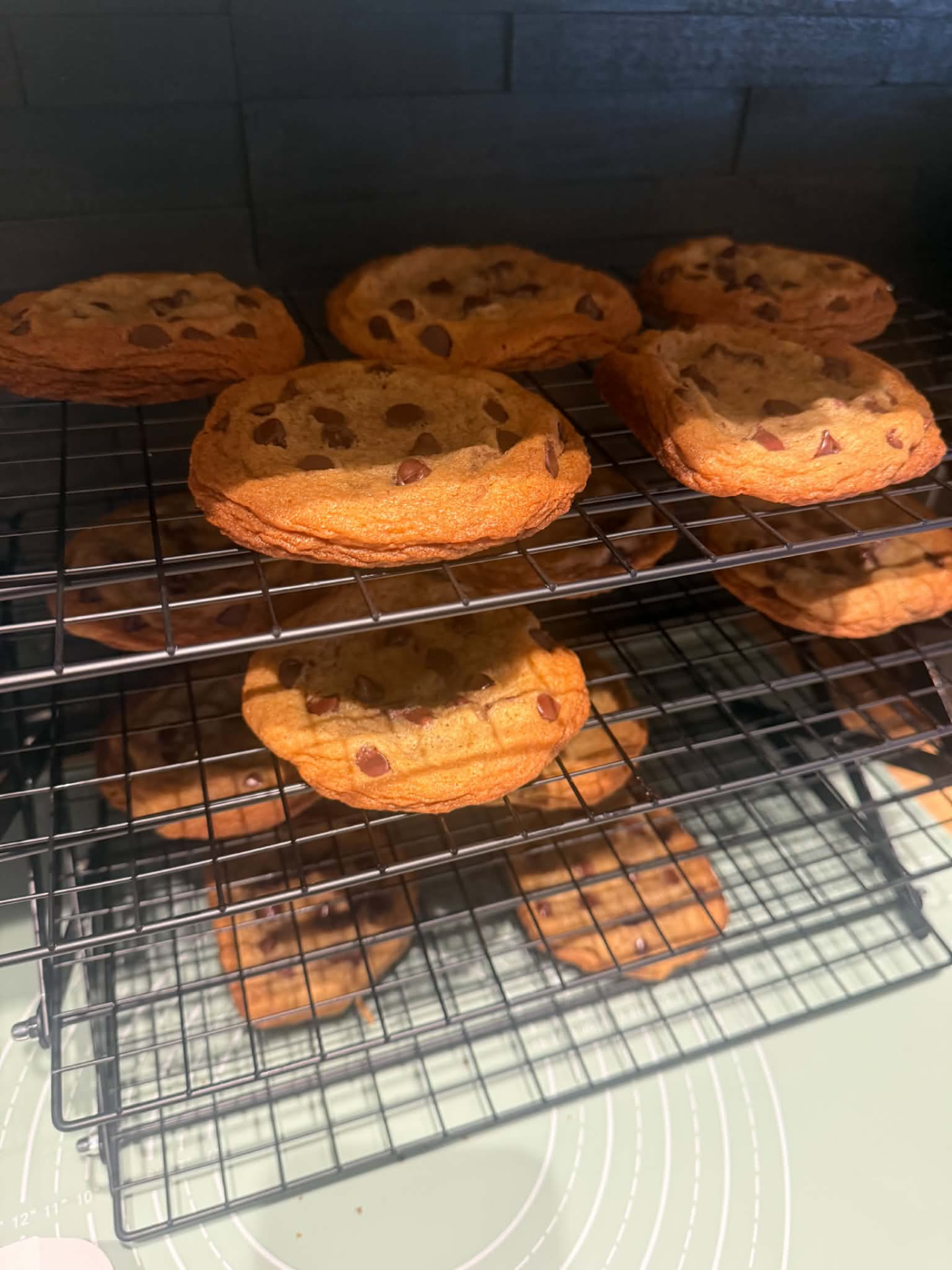 Fresh homemade chocolate chip cookies cooling on stacked wire racks