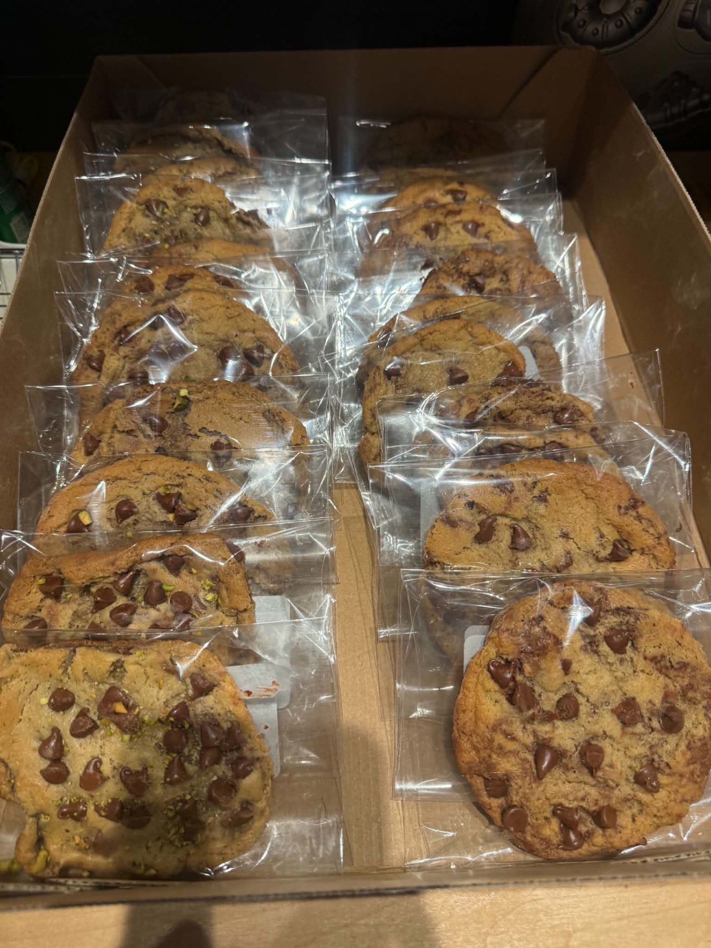 Rows of individually wrapped homemade cookies arranged in a bakery box